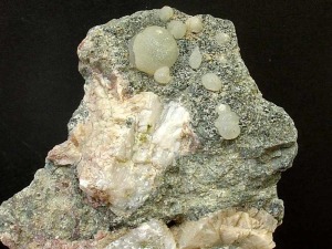 Agregados esfricos de cristales de prehnita con epidota (verde vivo) y titanitas (color miel) sobre ofitas de Los Baos de Gilico (Cehegn) [prehnita]