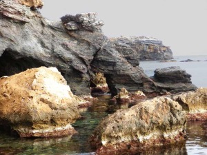 Arco natural en los esquistos de Cala Reona. En primer plano bloques desprendidos de calcarenitas