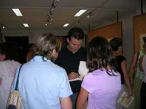 Firmando catlogos durante la inauguracin